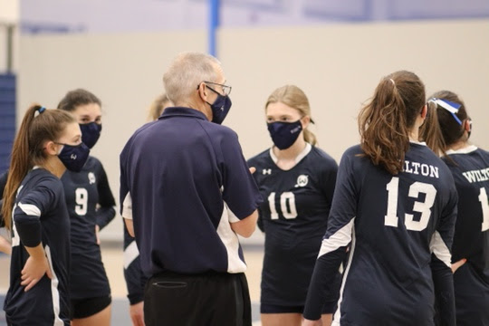 Coach Liptack huddles with his team during a match, following with a motivating speech.