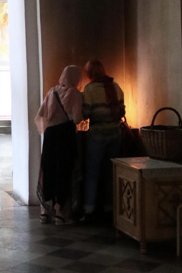 Simakova stands with her mother, lighting a candle in remembrance of those they care about.